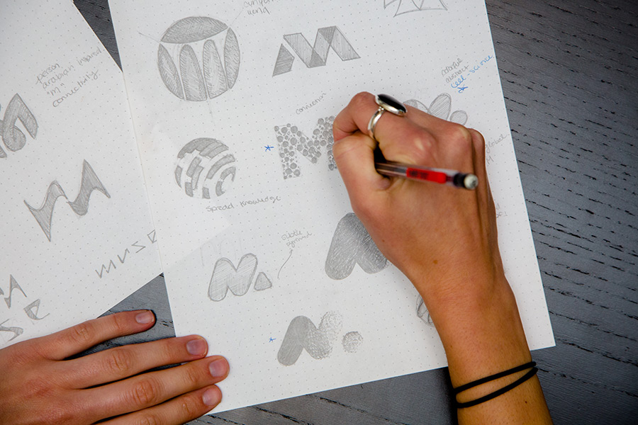Hannah Kinney, graphic designer at Kompleks Creative sketching logos.