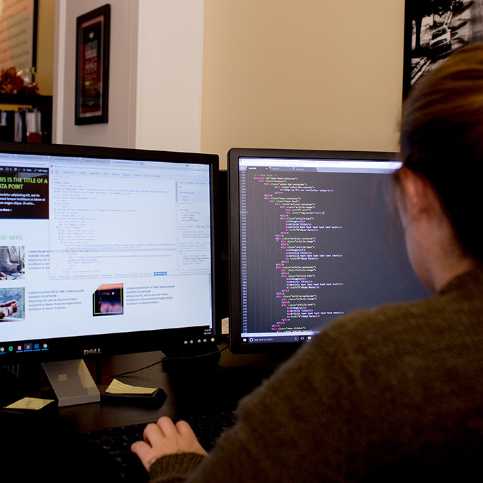 Kompleks Creative web developer, Kaitlyn Adam, coding a client website.